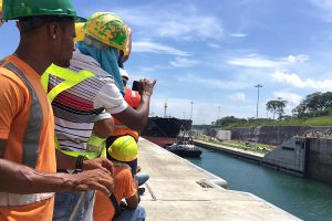 Justin Solomon | CNBC Hundreds of construction workers lined the sides of the new lane of the Panama Canal to watch the first ship, a post-Panamax ship pass through.